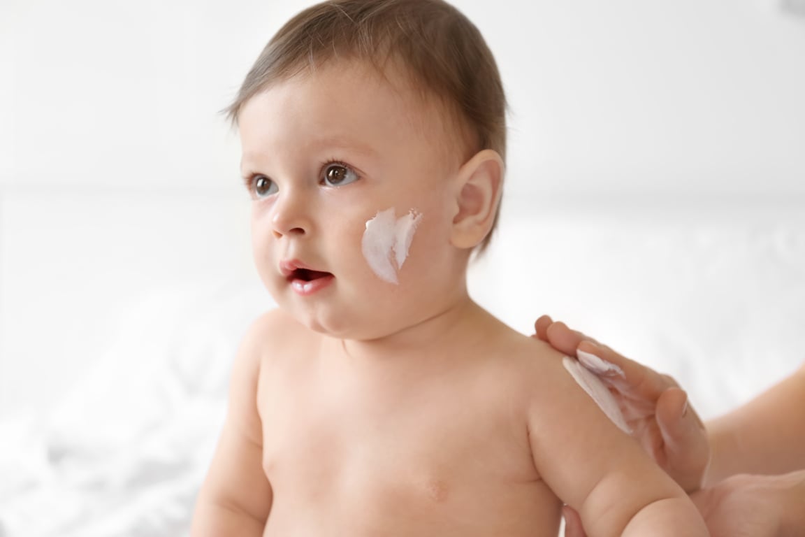 Woman Applying Cream on Her Baby