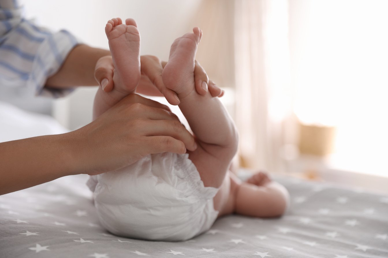 Mother Changing Her Baby's Diaper on Bed